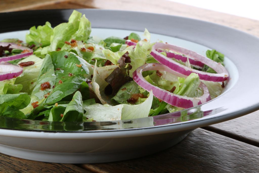 salada verde com tomate cereja e cebola roxa ao molho de vinagrete de ervas